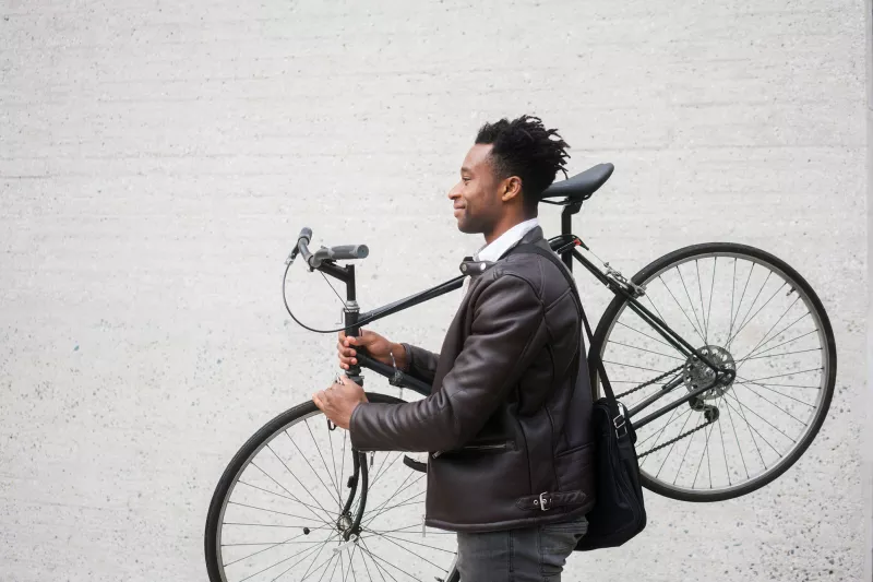 A man carries his bike after riding to work