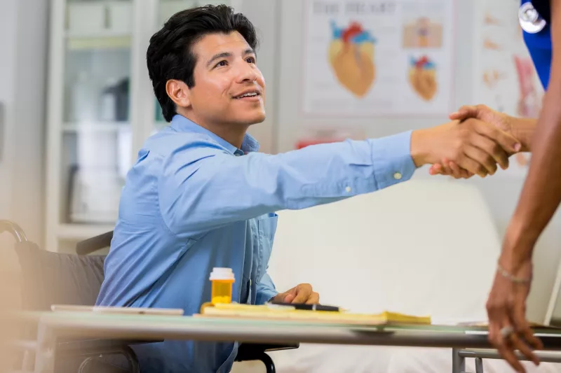 A man shakes the hand of a new doctor.