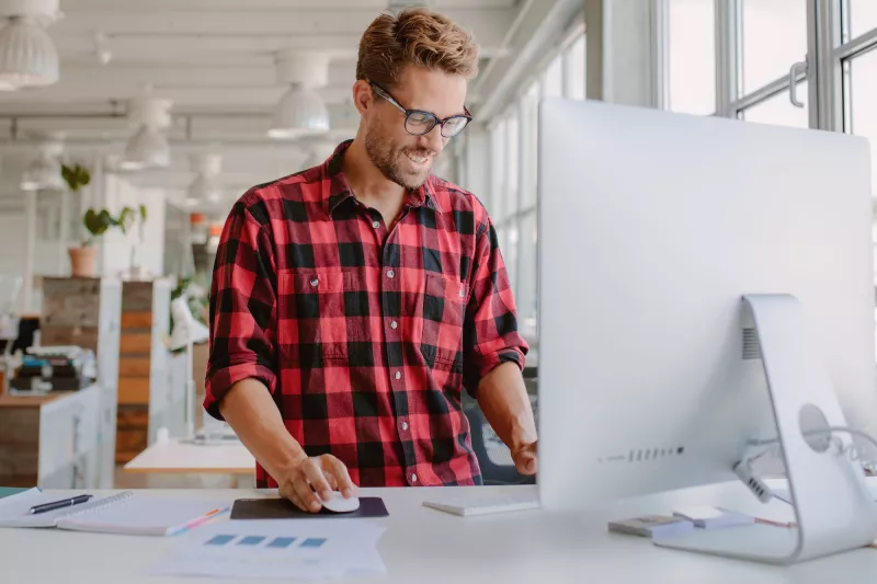 A man works at a standing desk.