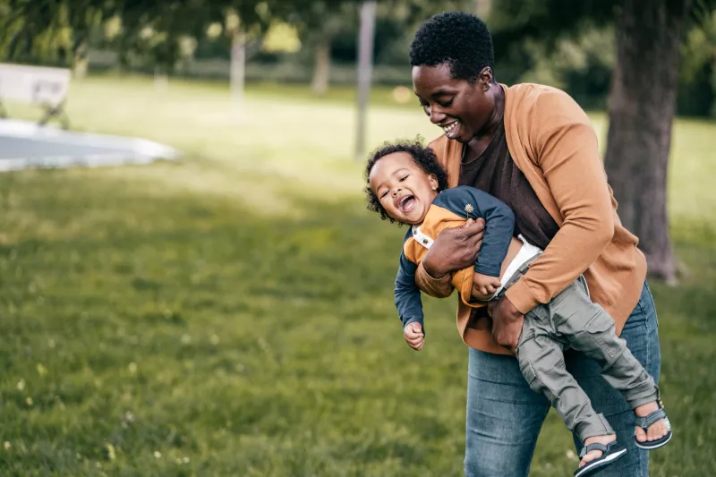 A mom and child playing outside.