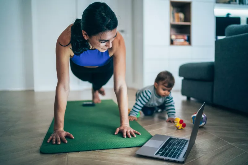 A mom exercising at home with her baby.