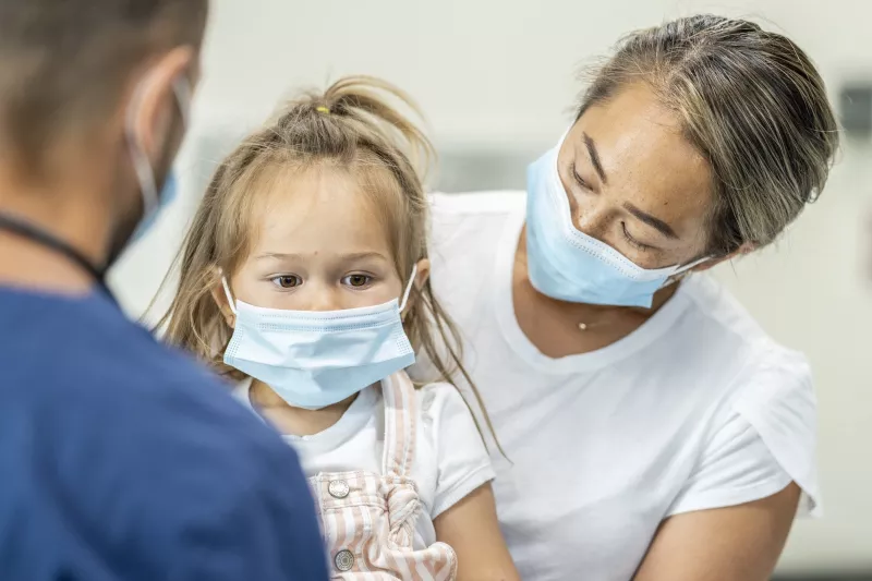 A mother at the doctor's office with her daughter.