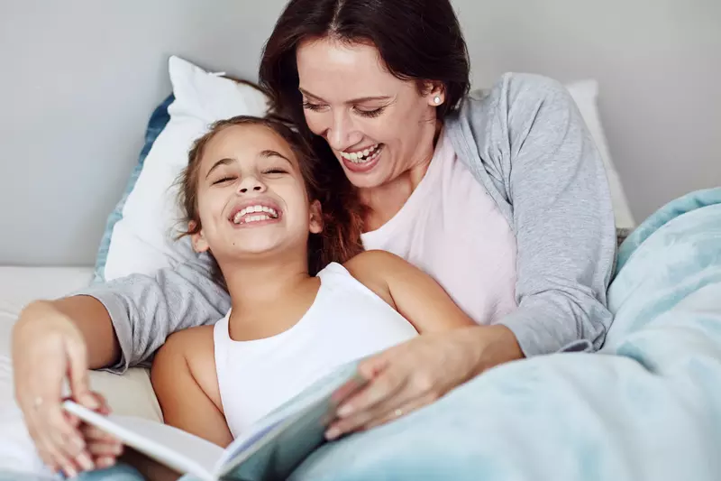 A mom reads her daughter a bedtime story.