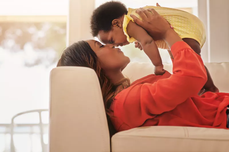 A mother kisses her baby.
