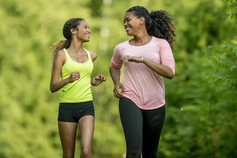 A mother running with her teenage daughter.