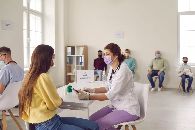 A nurse talking to a patient at a vaccine site