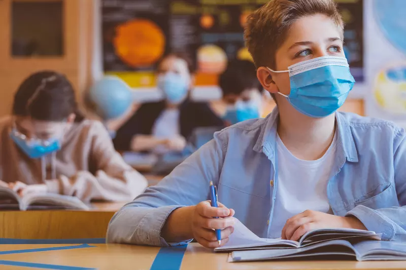 A student wearing a mask in the classroom. 