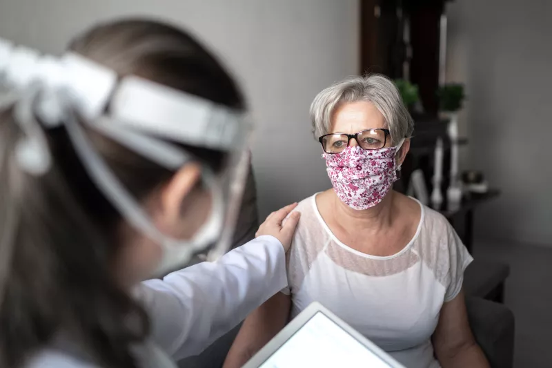 A physician reassuring her patient while they are talking