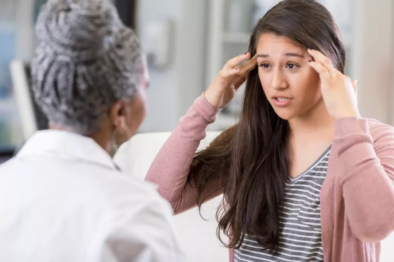 A woman discusses her symptoms with her doctor.