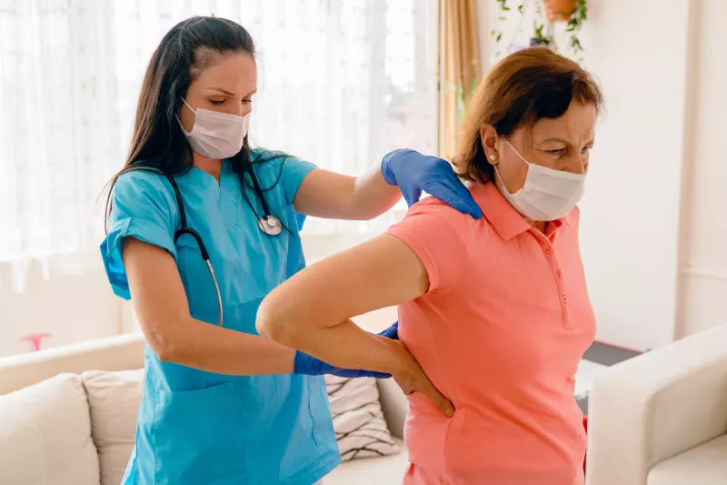 A woman being treated for back pain by her doctor.