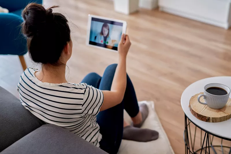 A women speaking to her doctor through her tablet