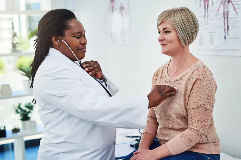 An adult woman gets her heart checked at the doctor office