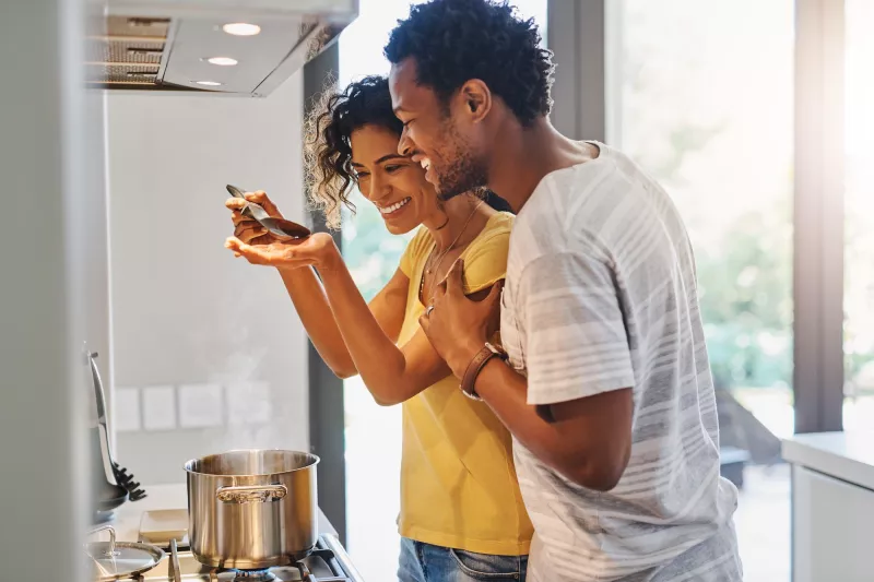 A young couple cooking in their kitchen at home.