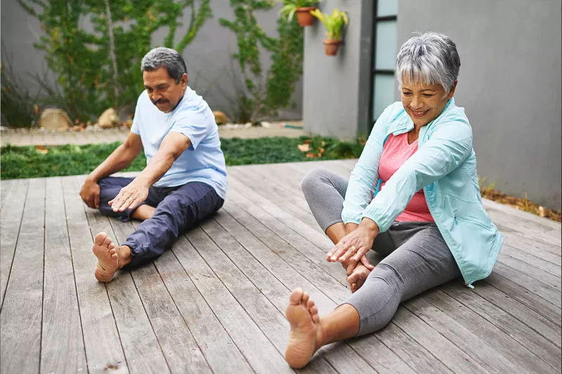 A couple doing leg stretches outdoors