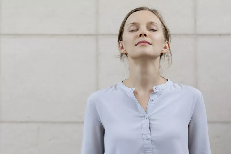 A woman takes a deep breath to stay calm during a lab test