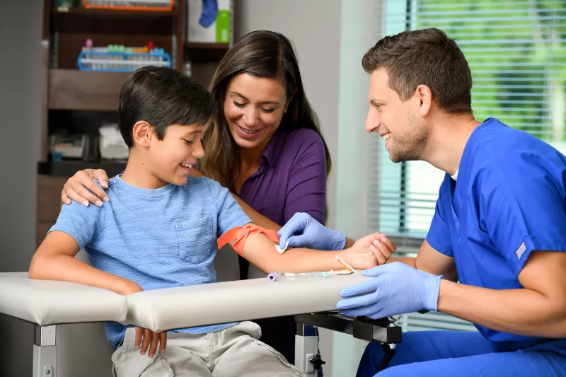 Male lab technician treating a young patient