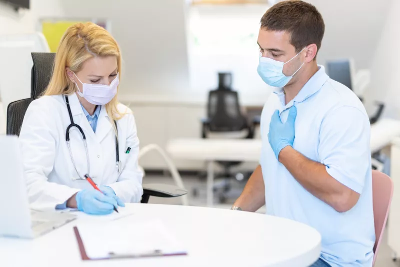 A man discussing his symptoms with his doctor.