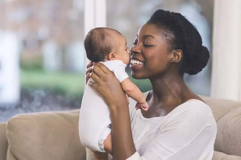 Mother holding her baby and smiling.