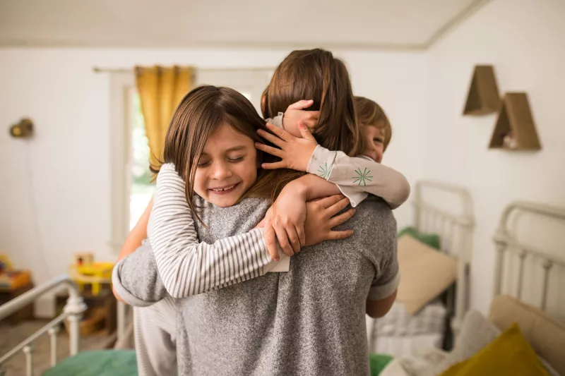 A mom getting warmed hugs from her kids.