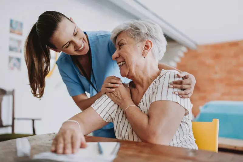 Nurse smiling with senior woman patient.