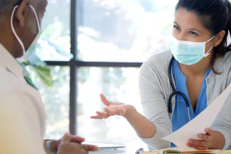 An older person speaking with his doctor.