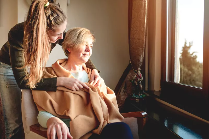 Younger woman taking care of female hospice patient