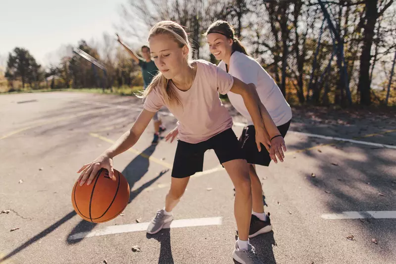 Young Girl Plays Basketball with Her Family