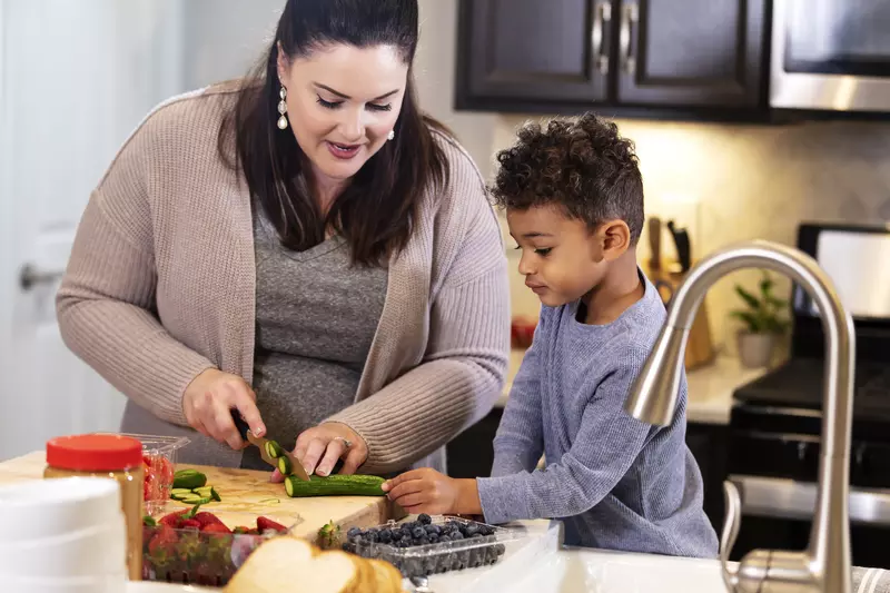 Woman Chopping Veggies with her son