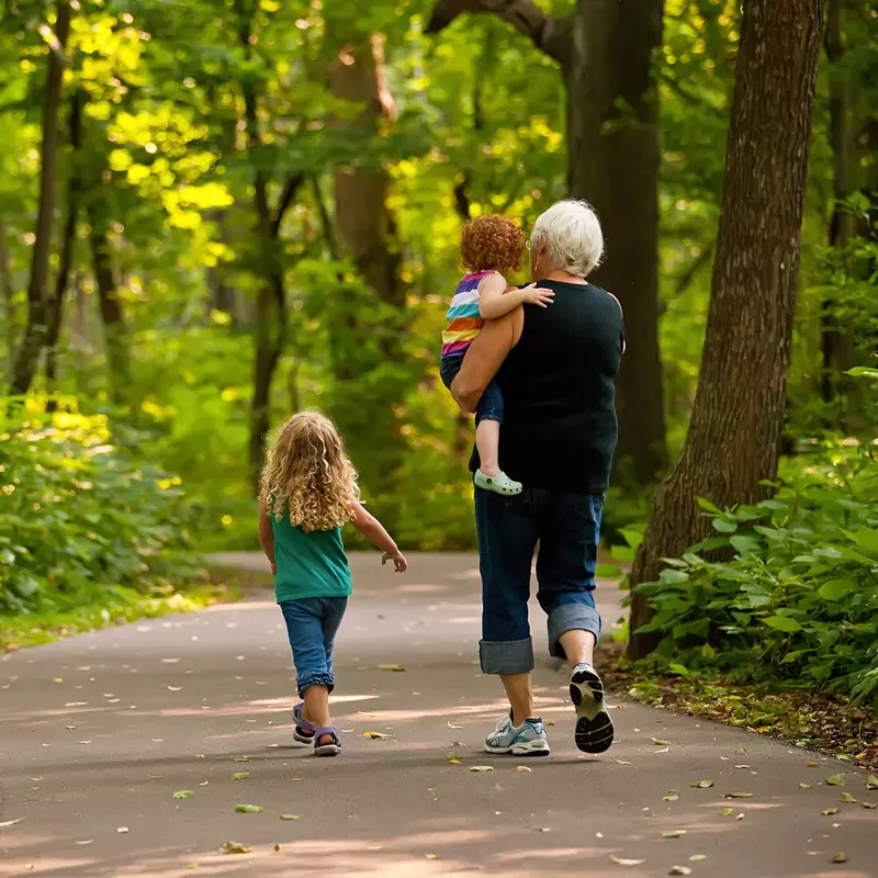 A Grandmother Walks 2 of her Grandchildren on a Path Through a Forest.