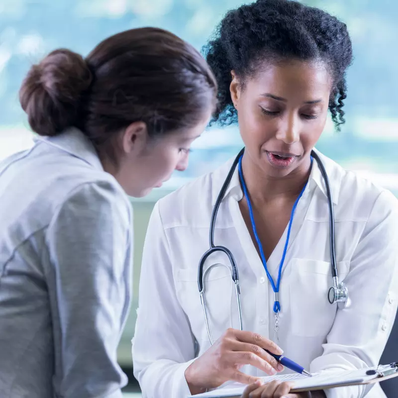 A Physician Goes Over A Chart With Her Patient 