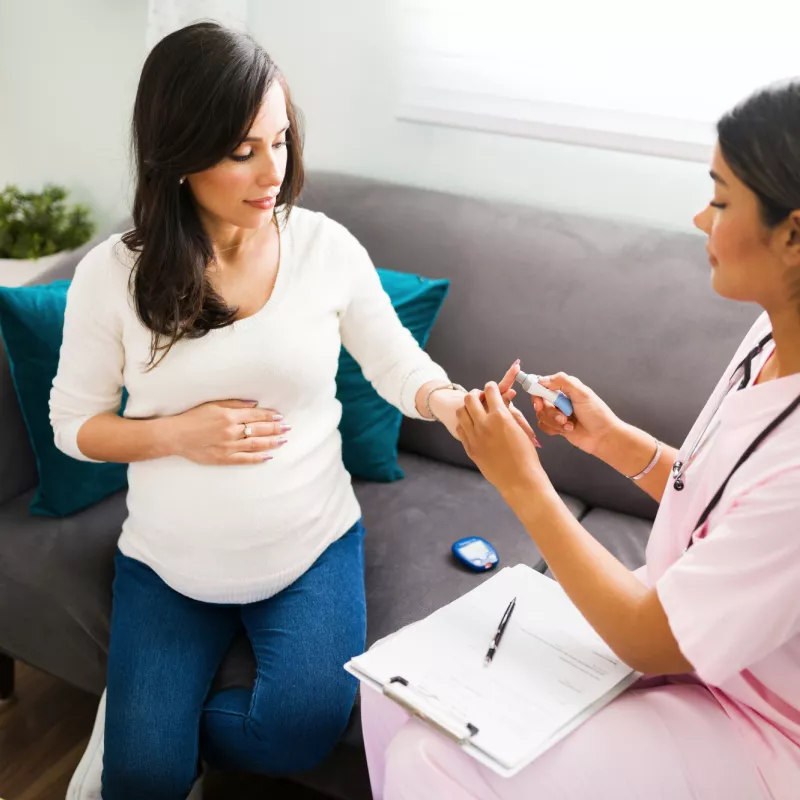 A Nurse Checks a Pregnant Patient's Blood Sugar at Her Home.