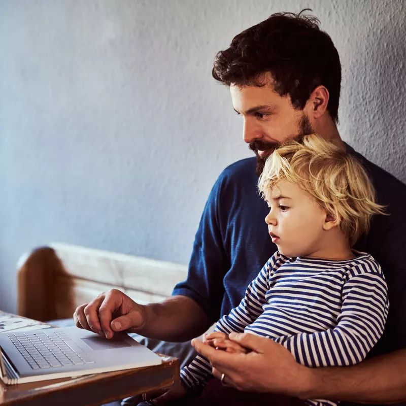 A Father and Son Sit and Surf the Internet From Home.