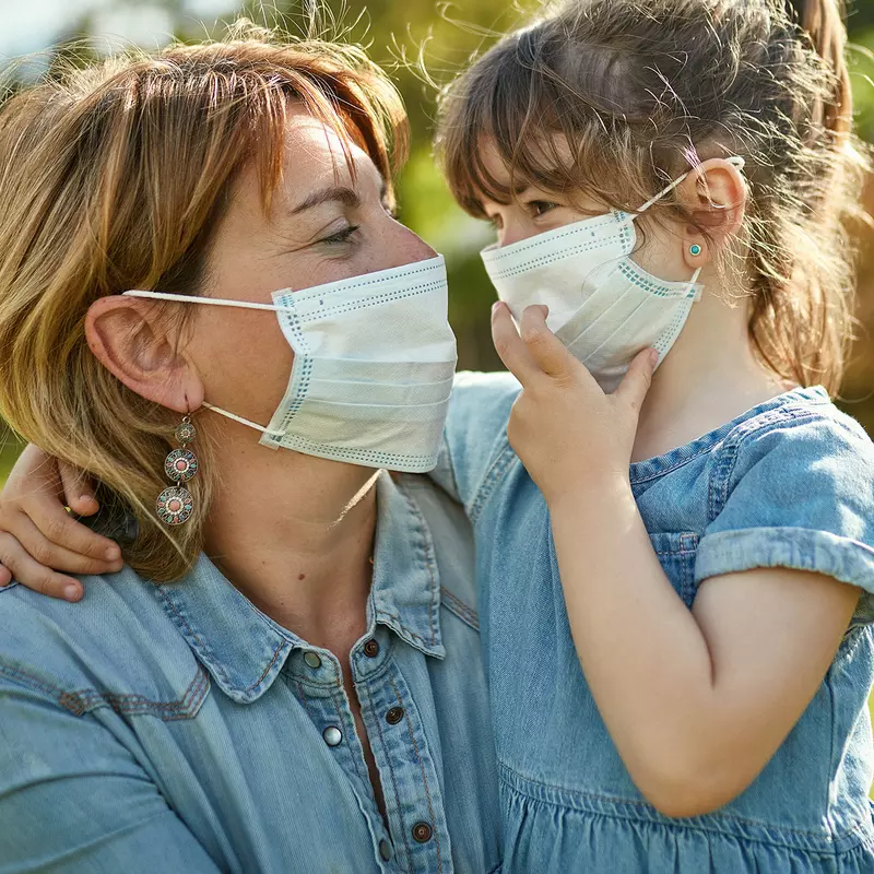 A mom and daughter wearing face masks.