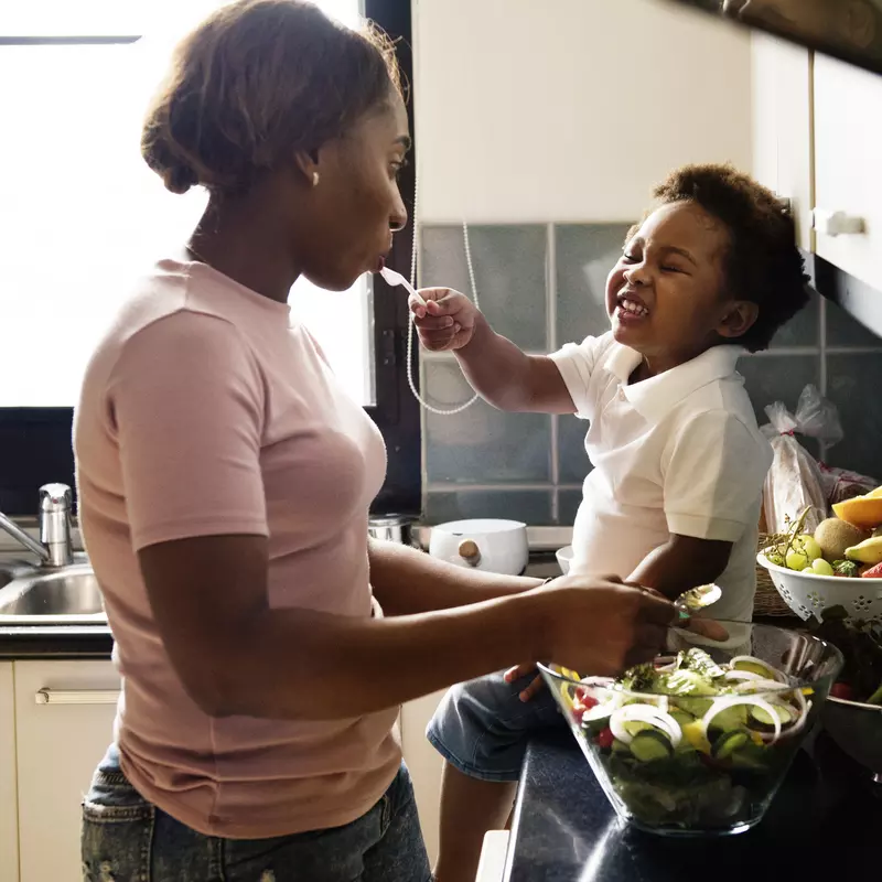 A mom prepares a meal for her family with the help of her toddler. 