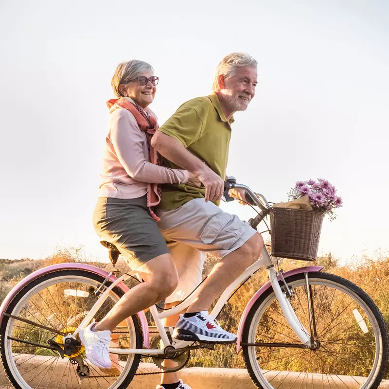 Older couple riding a bike together.