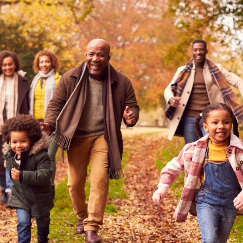 A family walking together outdoors in the fall.