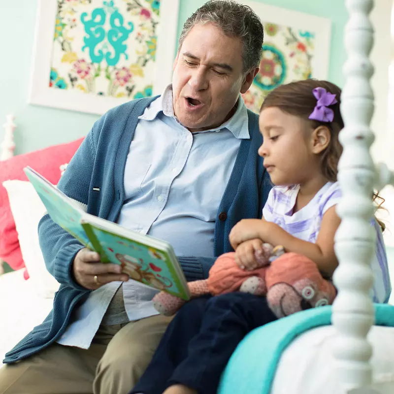 Grandfather reading a story to his grand daughter