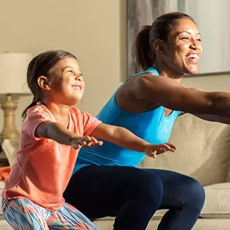 Mom and young daughter doing squats