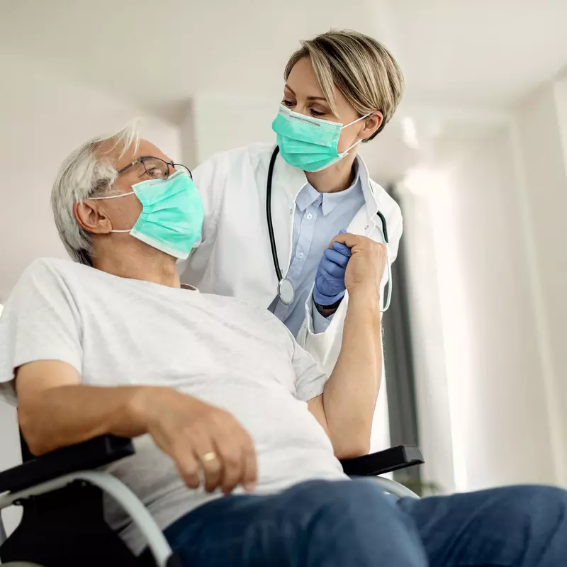 A senior man being assisted by a nurse