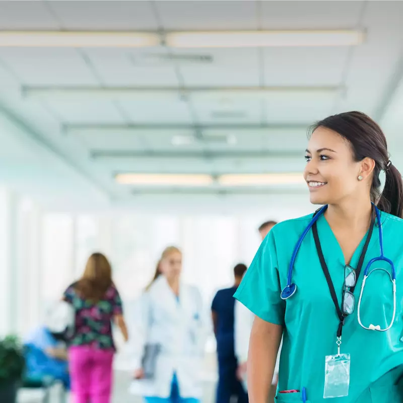 Female health care professional walking down hospital hallway