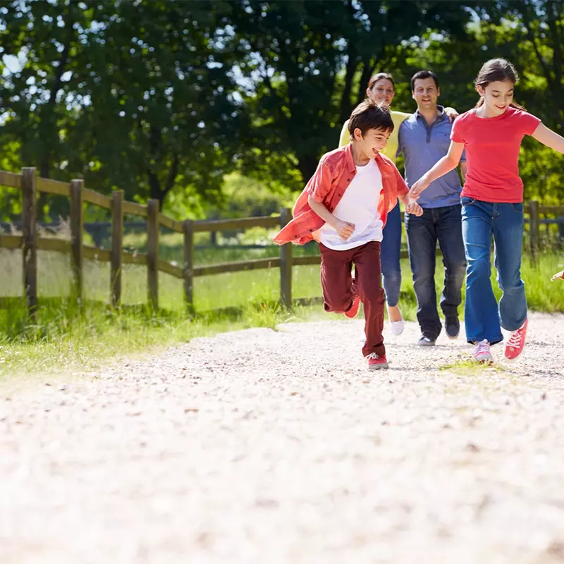 Family walking their dog along a dirt road