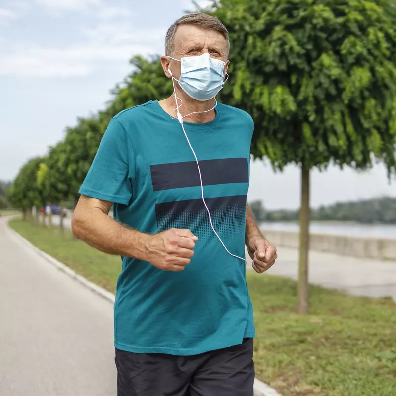 A man running outside wearing a mask.