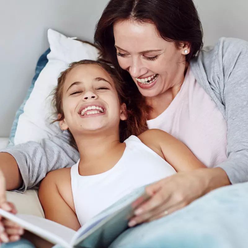 A mom reads her daughter a bedtime story.