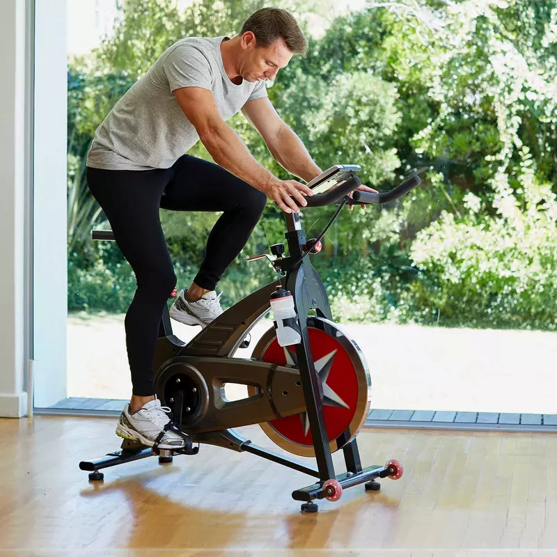 A man riding an exercise bike at home.