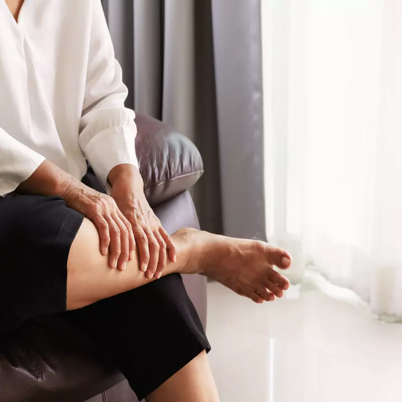 A woman massages her lower legs to relieve the pain