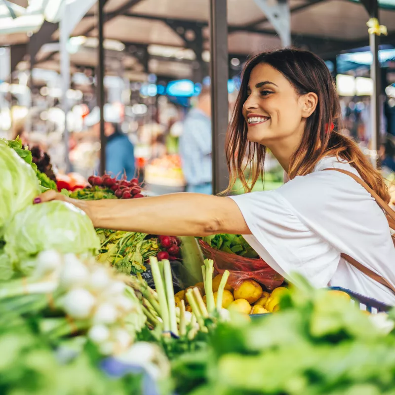 Young woman explores the farmers market for the best produce