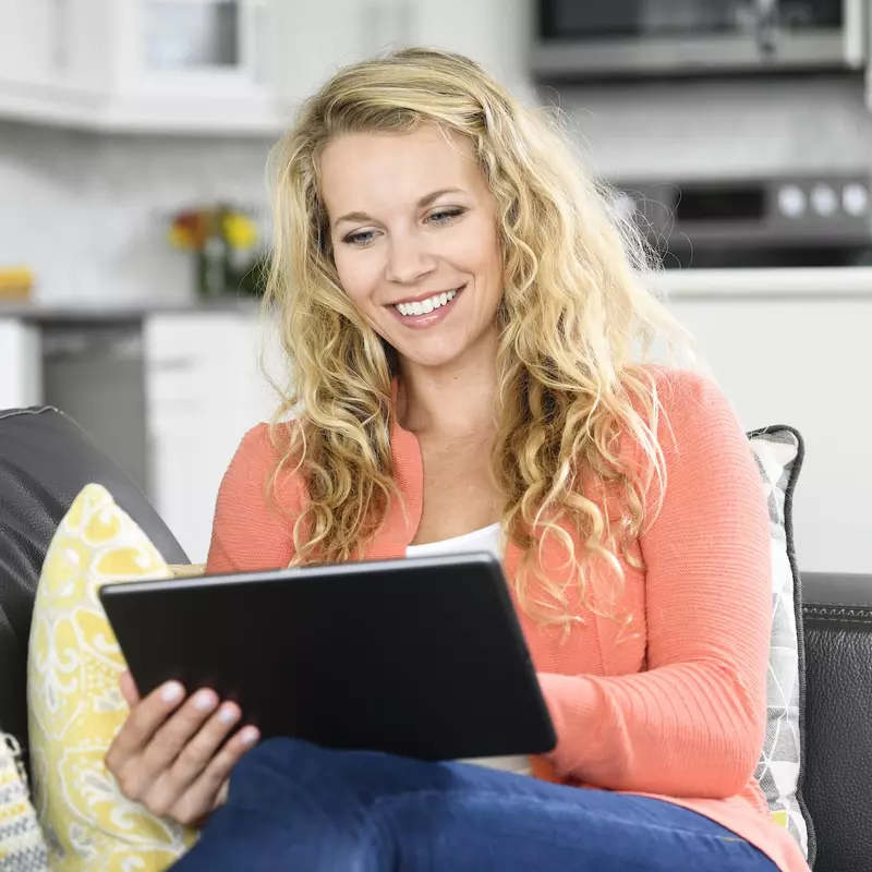 A woman reading on her tablet. 