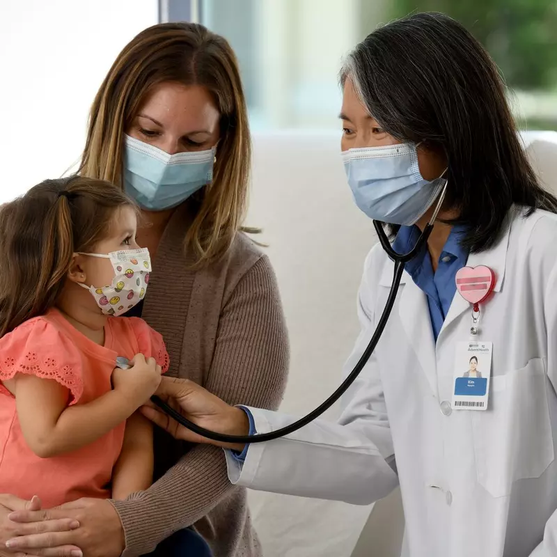 Doctor with little girl holding stethoscope 