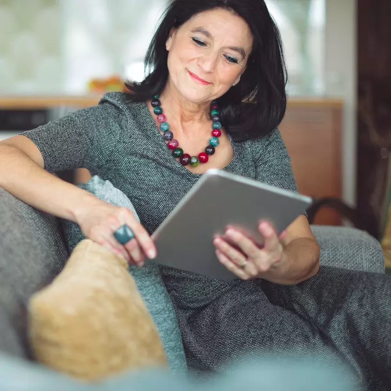 Woman using tablet on couch.