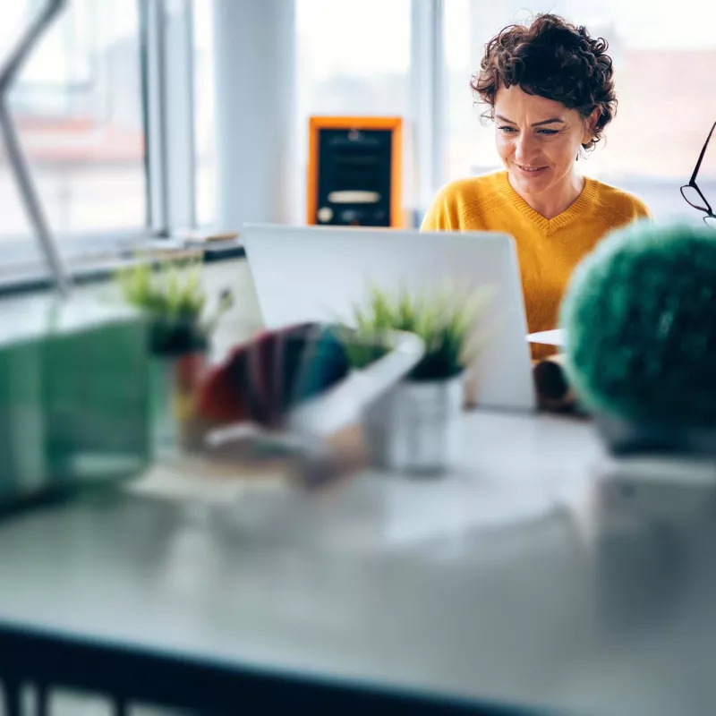 Middle-aged woman with laptop at desk